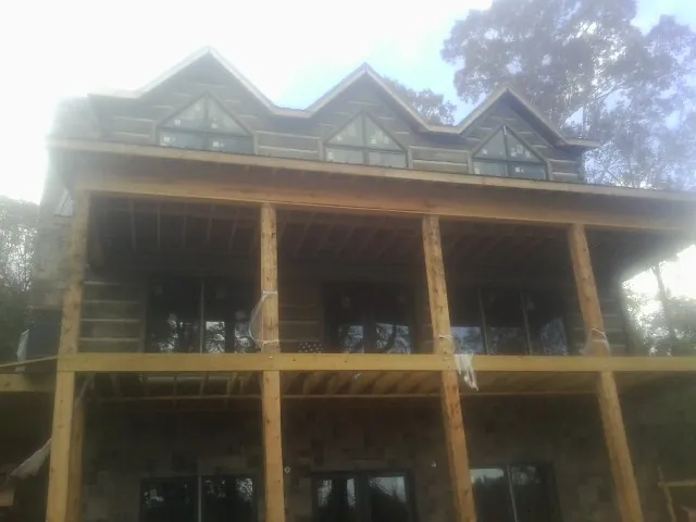 Dormers and porch framing on a large log home under construction — Roof Coating work by our crew in Hickman